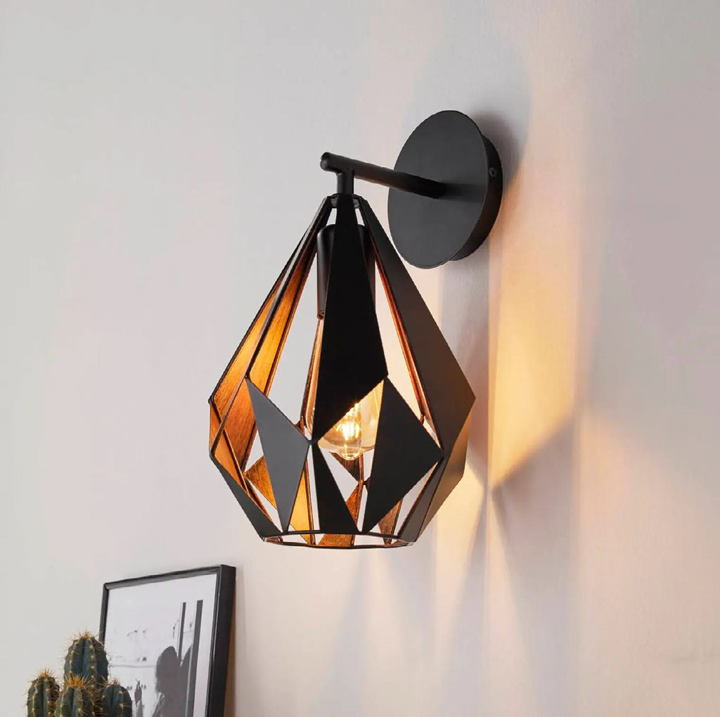 Black and copper vintage wall lamp with warm amber bulb